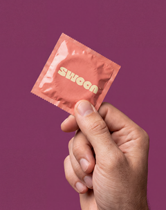 Hand holding a Swoon condom foil