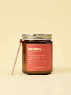 Swoon coconut apricot wax candle in an amber jar with a long match