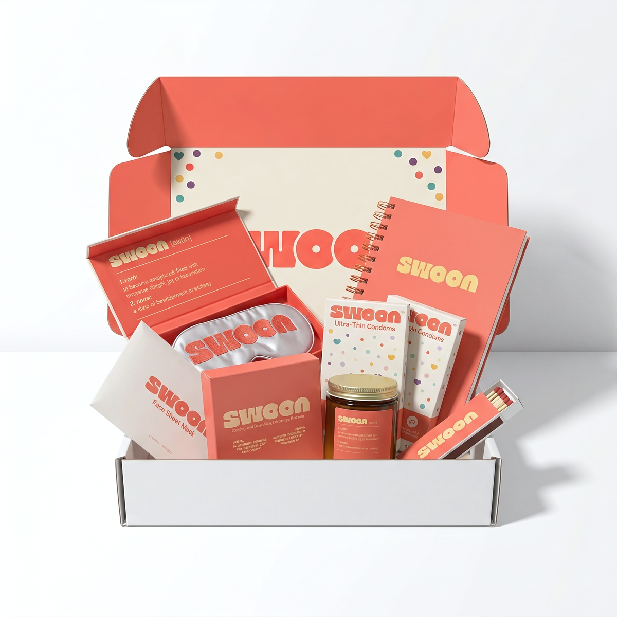The Swoon Kit gift box, open to show condoms, journal, candle, eye mask and skincare